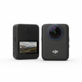 Two DJI action cameras on a reflective surface with a blurred natural background